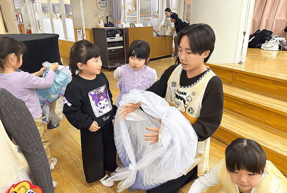 幼稚園で子どもたちと過ごす学生